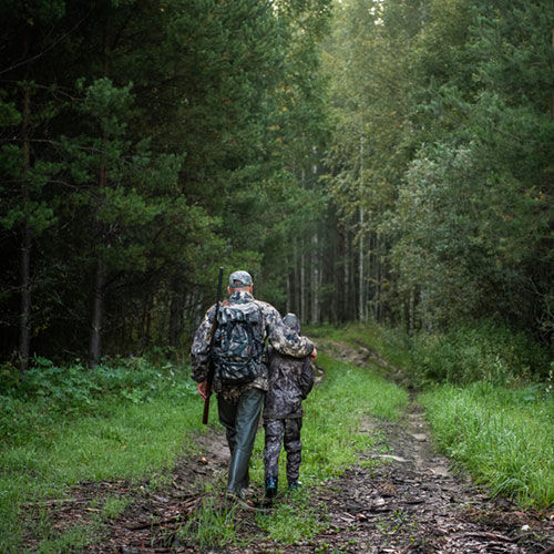 father and son walking in a wooded area